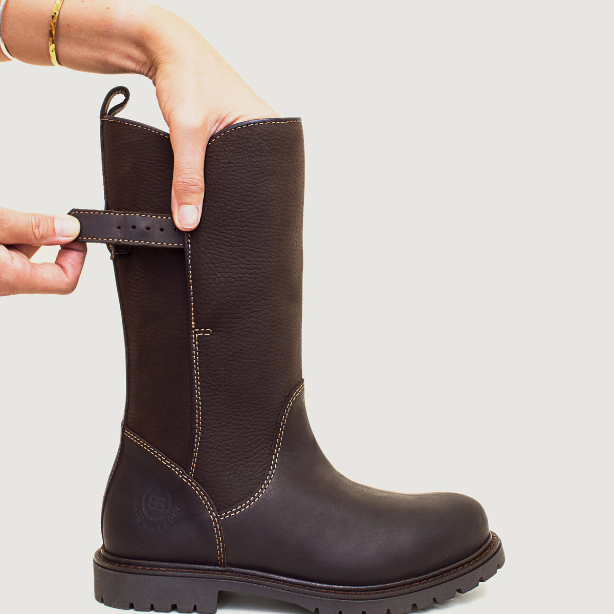 Bareback Quebec waterproof zip-up mid-calf boots in brown leather, close-up of a hand adjusting the buckle strap