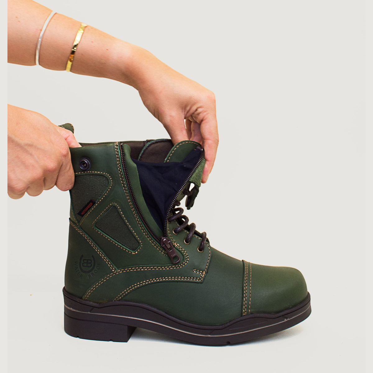 Bareback Kentucky Storm waterproof jodhpur boots in forest green, close-up of hands pulling the elastic gusset beside the zip