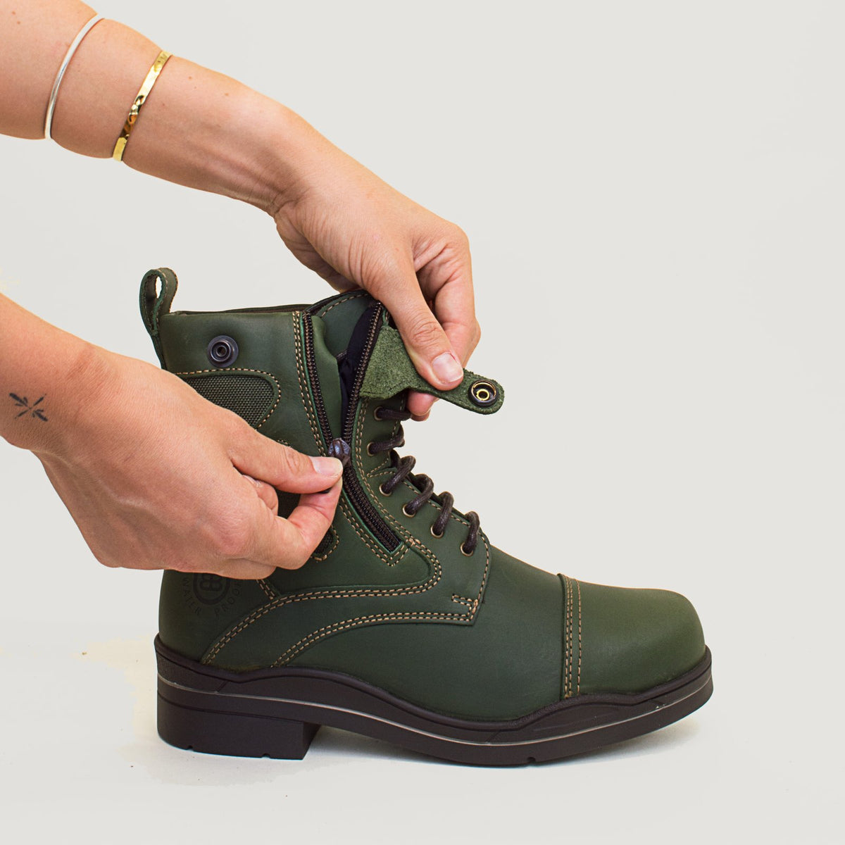 Bareback Kentucky Storm waterproof jodhpur boots in forest green, close-up of hands fastening the side zip