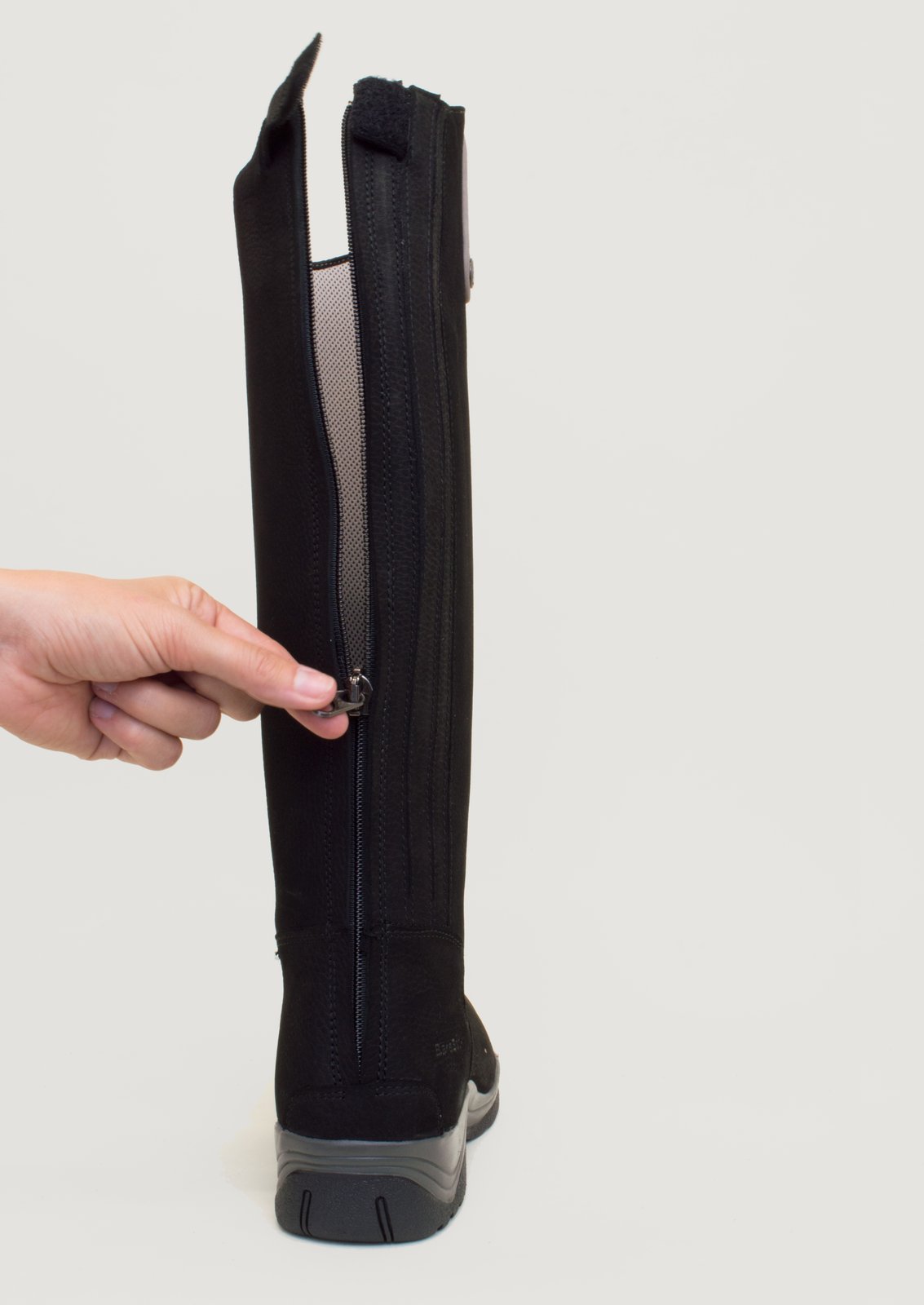 Hand opening the full-length rear zip on a Montana black riding boot