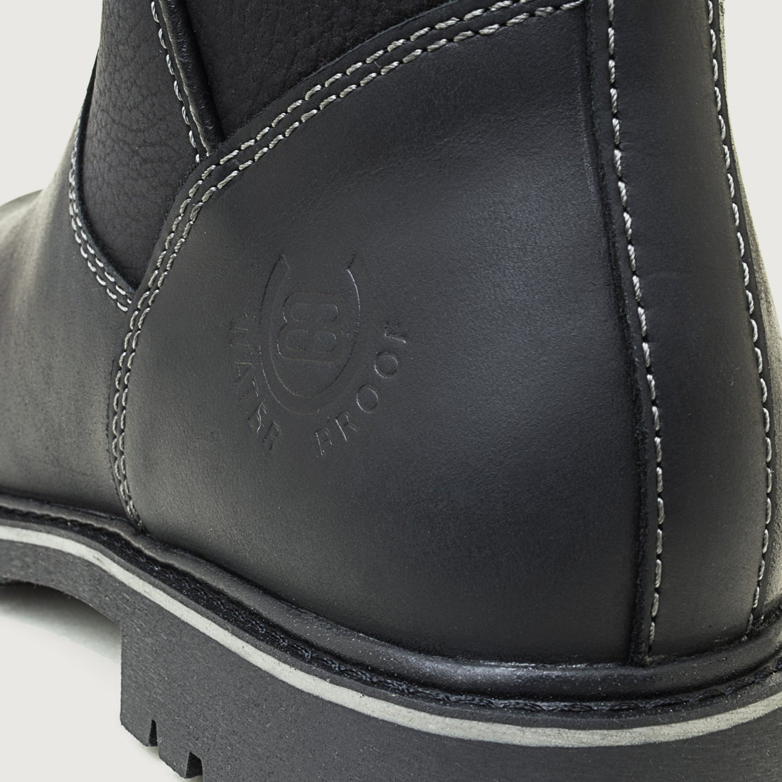 Bareback Quebec waterproof mid calf boots in black, close-up of the embossed waterproof logo on the heel