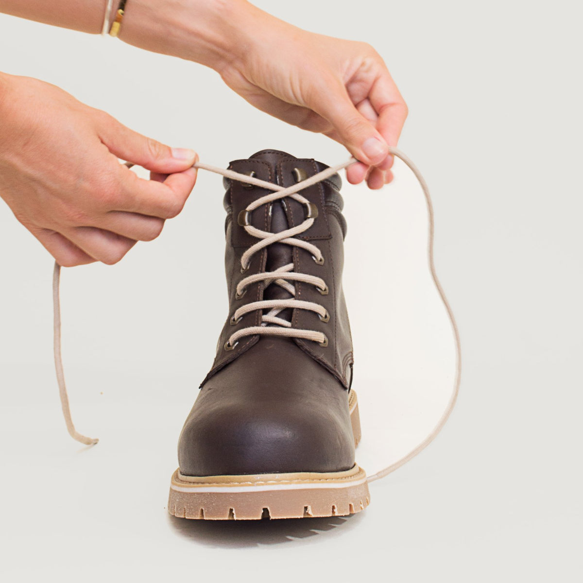 Bareback Rocky waterproof boots in brown, close-up of hands tightening the laces