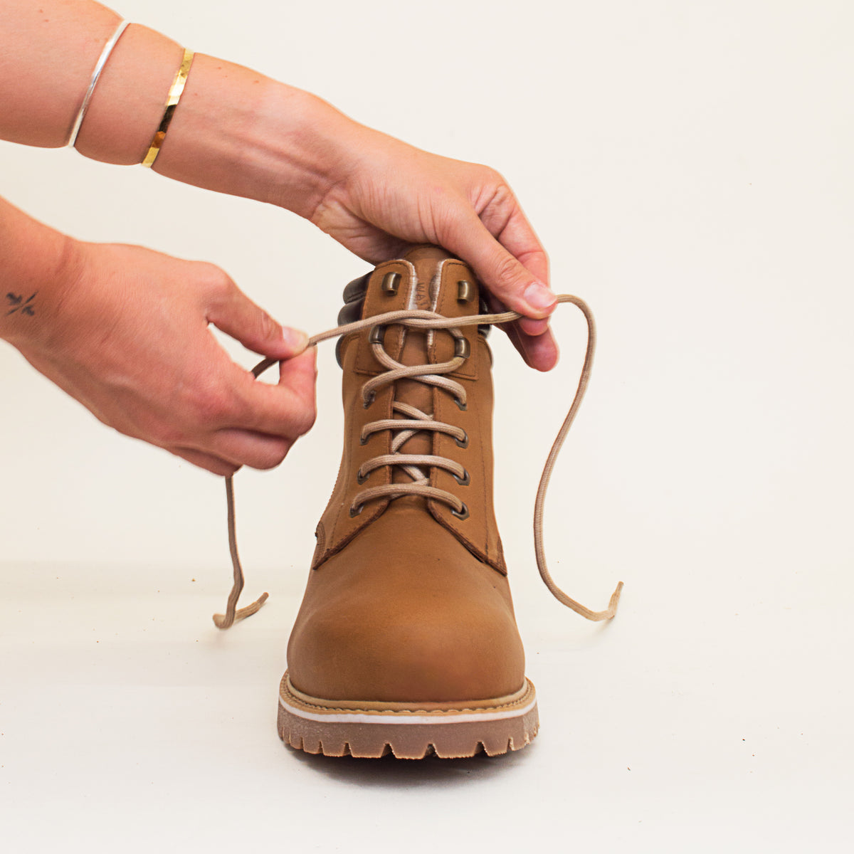 Bareback Rocky Winter waterproof boots in mocha, close-up of hands tightening the laces